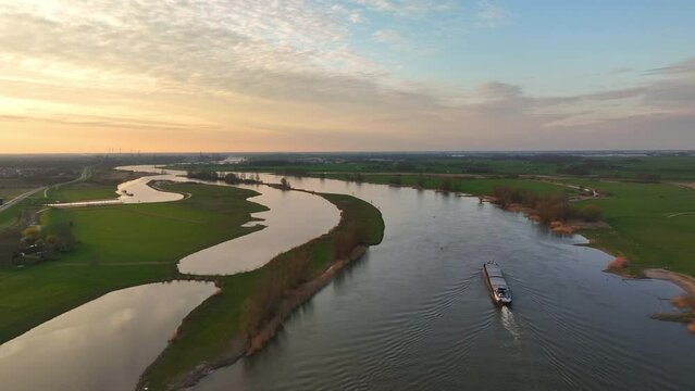 Ship sailing on the river IJssel in Overijssel aerial view during a springtime sunset.