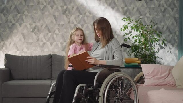 Loving mom with disability reads little daughter fairytale