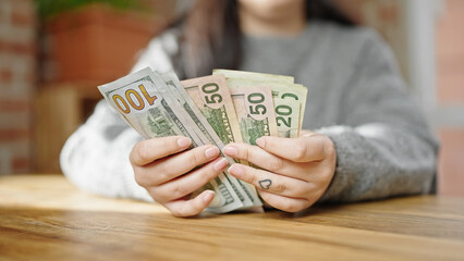 Hands of woman counting dollars at room