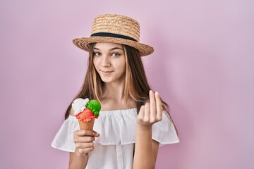 Teenager girl holding ice cream doing money gesture with hands, asking for salary payment, millionaire business