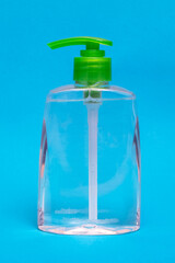 Green liquid soap dispenser on blue background