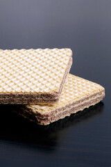 Two chocolate waffles on a wooden table