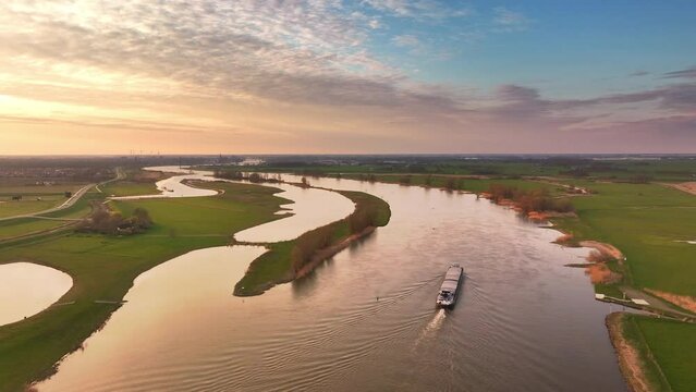 Ship sailing on the river IJssel in Overijssel aerial view during a springtime sunset.