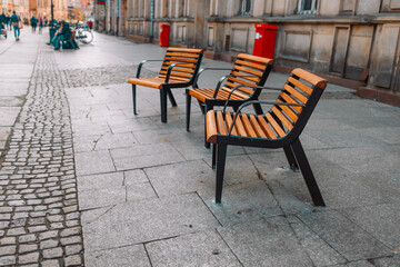 Fototapeta na wymiar Closeup of outdoors comfortable street furniture chairs and table on city street in Gdansk, Poland. 