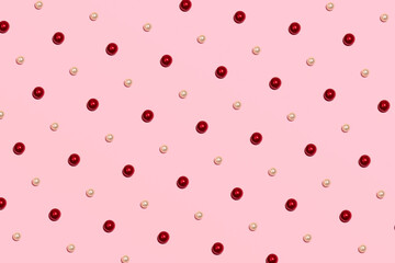 Red and white glossy pearl beads, creative cute romantic pattern, pastel pink background.