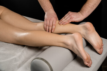 Foot and legs massage in spa. Masseur making foot and legs massage with massage oil. Relaxation.