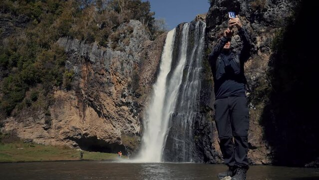 Caucasian man talking a selfie with phone at Hunua Falls, Auckland Region. New Zealand. September 2020