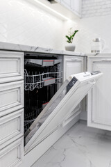 Dishwasher with open door in the modern kitchen photographed close-up