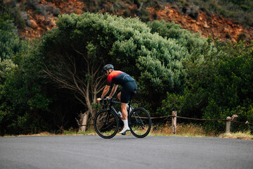 Back view of male cyclist riding a bicycle in wild terrain