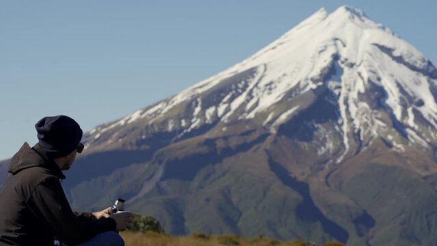 Young man pouring water on argentinian drink called mate in Mount Taranaki, New Zealand