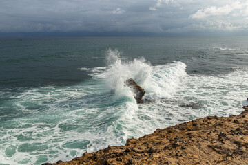 Fototapeta na wymiar Waves of the Pacific Ocean crashing against the rock at La Chocolatera. Santa Elena province, Salinas, Ecuador