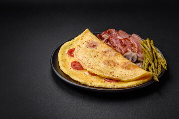 Delicious fresh omelet with cherry tomatoes, bacon, asparagus and spices