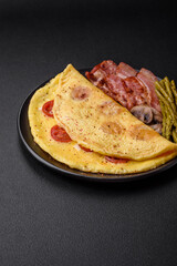 Delicious fresh omelet with cherry tomatoes, bacon, asparagus and spices