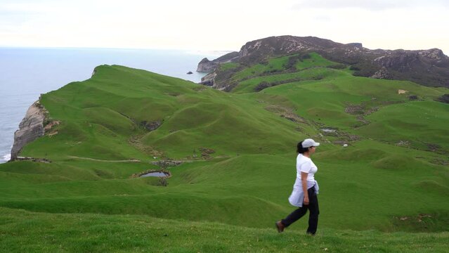 Woman walking among the hills in Golden Bay Region, New Zealand