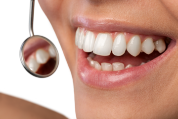Woman teeth and a dentist mouth mirror on background