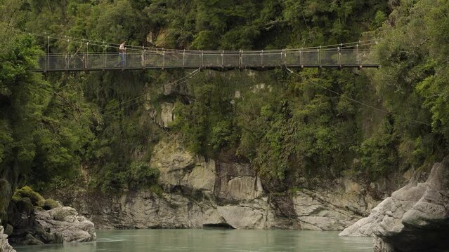 Hokitika Gorge suspension bridge and a man crossing it. New Zealand West Coast.