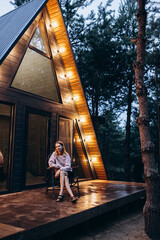 A frame triangle holiday house in the woods at night, peaceful weekend getaway in nature. Photo of...