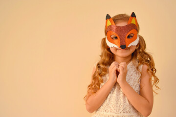 A child in a masquerade carnival mask of a fox, hand-made from glitter foamiran. Little cute...