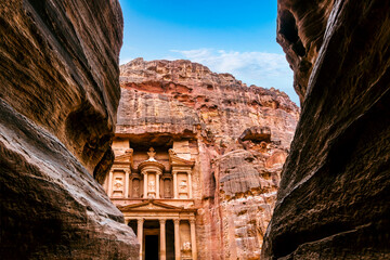 Obraz premium The ancient Treasury Building or Al Jhazneh, seen from the Siq, a narrow gorge through the sandstone canyon in Petra, Jordan. 