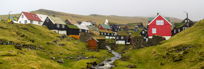 The brook passing by Mykines hamlet tuf roofed houses