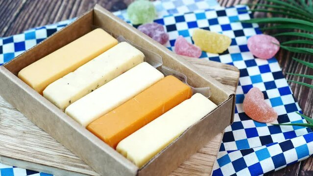 Cheese cubes green, yellow and red color on chopping board 
