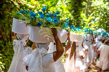 Praia de Trancoso, Bahia, Brasil. 2 de fevereiro de 2023. Mulheres carregando cestos de flores em Festa popular para celebrar o Dia de Iemanjá, o evento atrai pessoas de religiões afro-brasileiras - obrazy, fototapety, plakaty