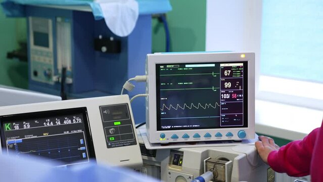 Equipment with screens switched on during operation. Modern medical apparatuses working in surgery room.