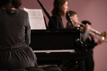 A person playing the piano in a class with students