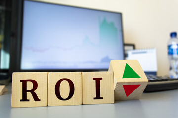 ROI concept. wooden cubes with roi inscription and cube with up and down arrows