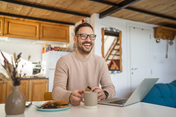 One man caucasian male online shopping use laptop and hold credit card