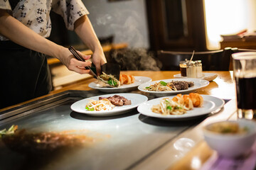 Tepanyaki - japanese grilled beef on pan. chef cooking at the hot table