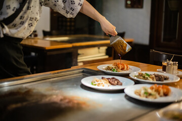 Tepanyaki - japanese grilled beef on pan. chef cooking at the hot table