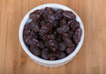 raisins in a bowl wooden background
