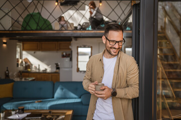One adult man stand in at door of tiny house happy smile hold cup