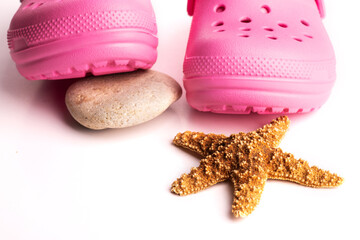 Pink children's sandals  close-up and a starfish. Isolated on white background.