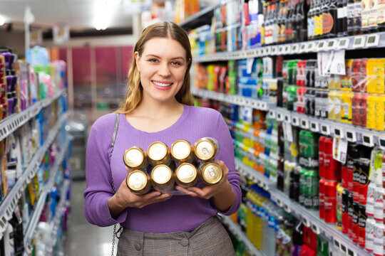 Portrait of nice female customer shopping beer in hypermarket.