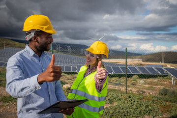 Two engineers of different ethnicities together at work give thumbs up, partnership and teamwork