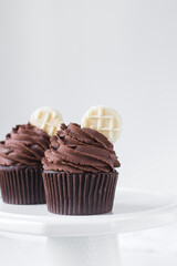 Chocolate cupcake with dark chocolate buttercream, double chocolate cupcakes with american buttercream, tall swirl frosting on a cupcake with a wafer