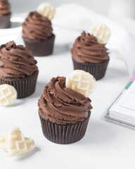 Chocolate cupcake with dark chocolate buttercream, double chocolate cupcakes with american buttercream, tall swirl frosting on a cupcake with a wafer