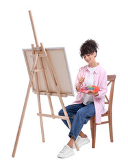 Young woman painting on easel with canvas against white background