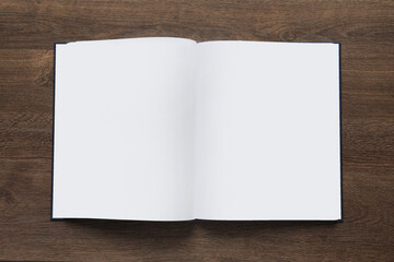 Open book on wooden table, top view