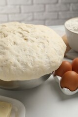 Fototapeta na wymiar Fresh yeast dough, eggs and ingredients on white table. Making cake