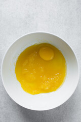 Eggs, Melted butter and sugar in a white mixing bowl, process of making muffins