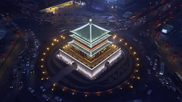Vehicles drive in traffic circle around Bell Tower on Xian China night