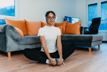 Naklejka na ściany i meble A woman stretching in her apartment during early morning after training , reflecting her dedication to a healthy lifestyle. This moment highlights the importance of regular exercise and self-care