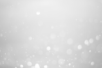 White glitter vintage lights background.  White bokeh shiny on dark background.