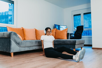 Fototapeta premium A woman stretching in her apartment during early morning after training , reflecting her dedication to a healthy lifestyle. This moment highlights the importance of regular exercise and self-care