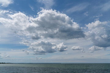 Naklejka na ściany i meble Cumulus clouds over the Baltic Sea on the coast of the resort town on a sunny summer day, Zelenogradsk, Kaliningrad region, Russia