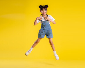 Fototapeta na wymiar image full body of asian little girl posing on a yellow background
