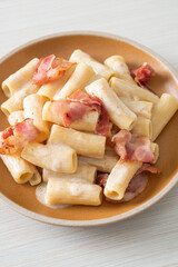 spaghetti rigatoni pasta with white sauce and bacon